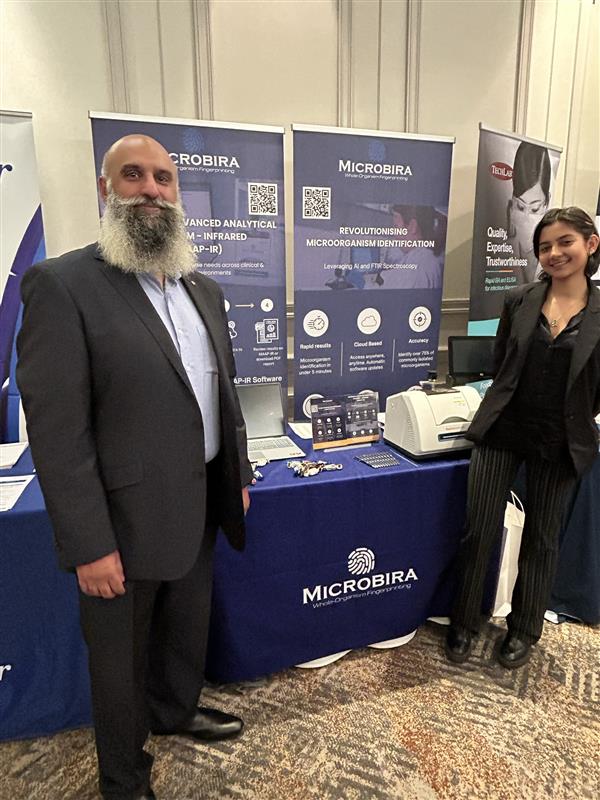2 employees standing in front of the Microbira exhibition stand at WMA